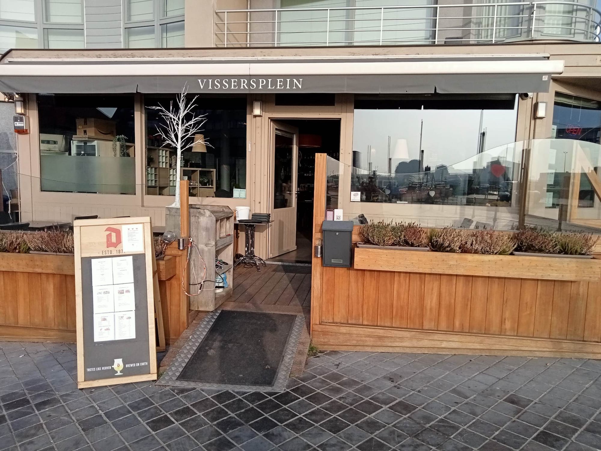 De gevel van Bistro Vissersplein met luifel en houten terras aan het Vissersplein in Oostende