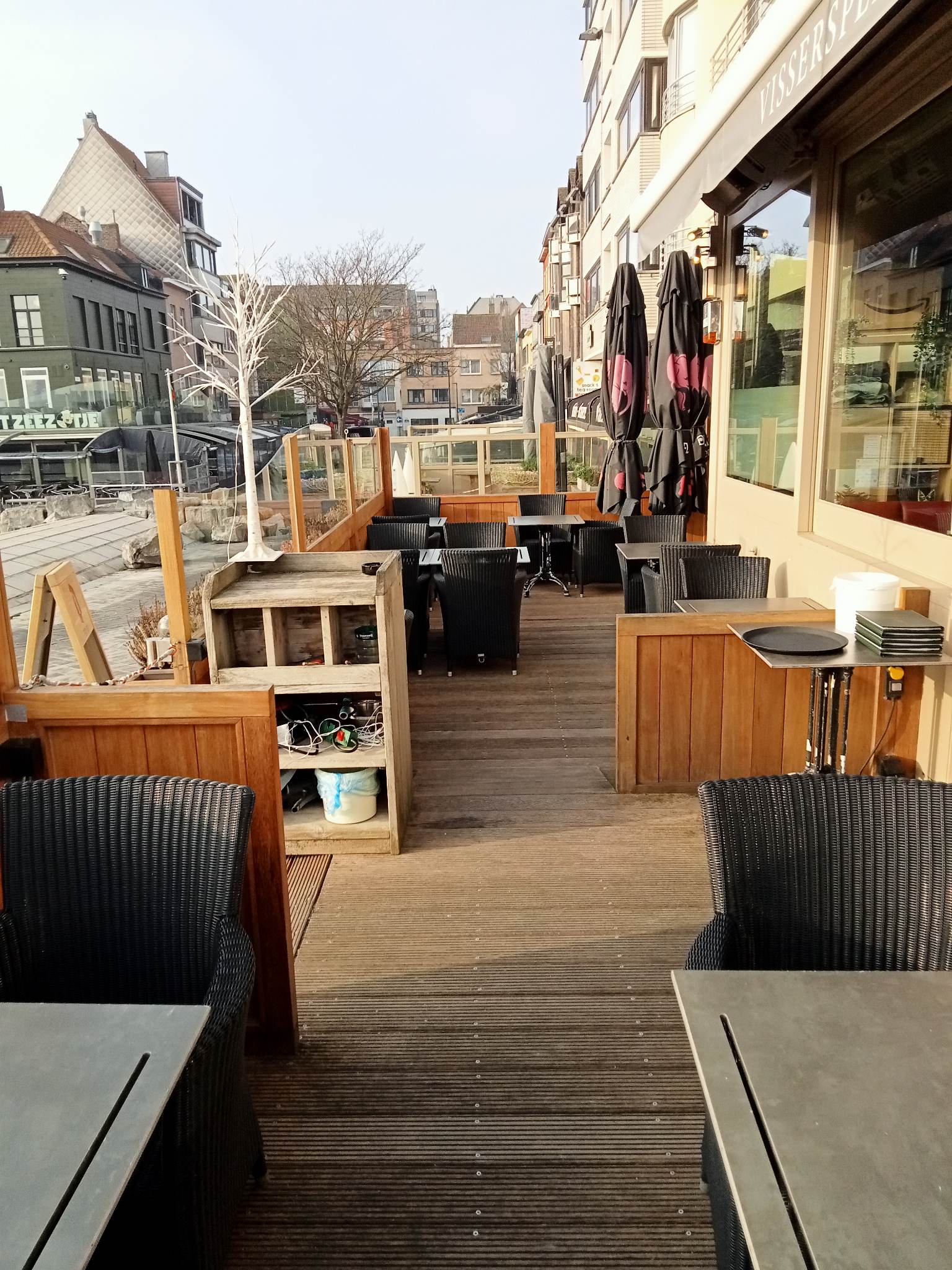 Het terras van Bistro Vissersplein met rieten stoelen en zicht op het plein