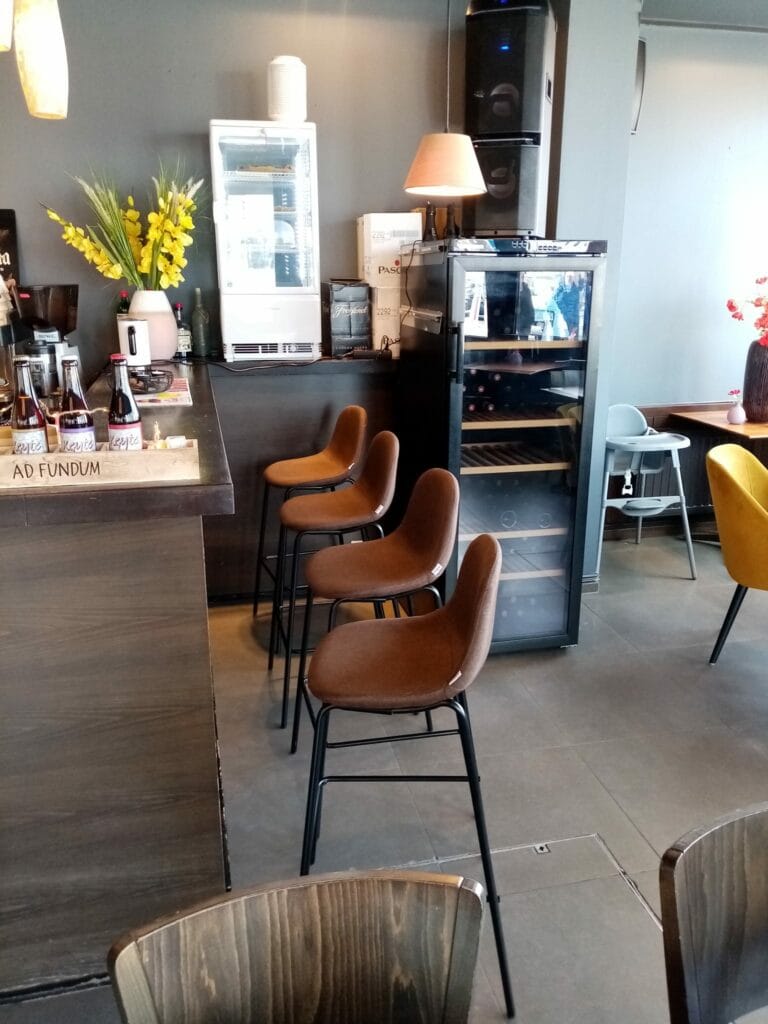 De toog van Bistro Vissersplein met barkrukken, verse bloemen en warme verlichting